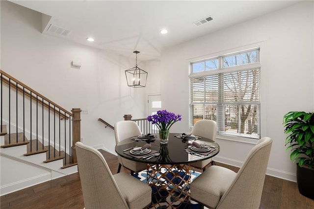 dining area with dark hardwood / wood-style flooring and a chandelier