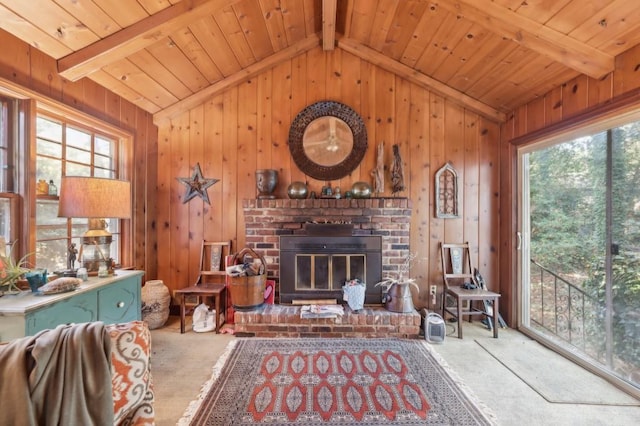 living room featuring carpet flooring, lofted ceiling with beams, a fireplace, and a wealth of natural light