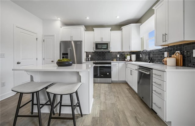 317 Foxglove Way, Mcdonough, GA 30253 - kitchen featuring stainless steel appliances, a sink, light wood finished floors, a kitchen bar, and recessed lighting