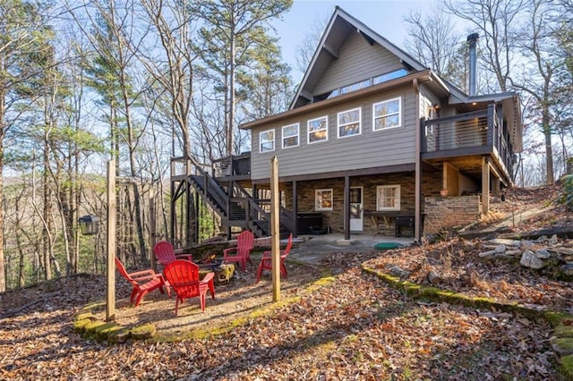 rear view of property featuring a wooden deck and a patio area