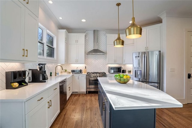 kitchen featuring white cabinetry, wall chimney range hood, and stainless steel appliances