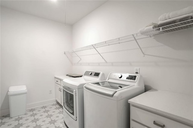 washroom featuring washer and clothes dryer and cabinets