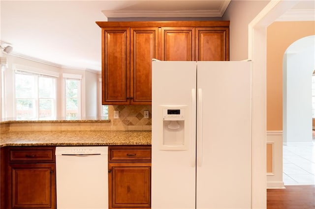 5287 Wild Indigo Way, Acworth, GA 30102 - kitchen with white appliances, arched walkways, brown cabinets, light stone countertops, and crown molding