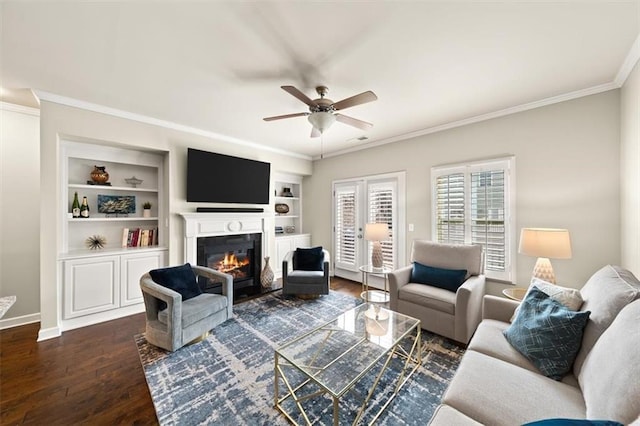 living room featuring crown molding, ceiling fan, dark hardwood / wood-style flooring, and built in shelves