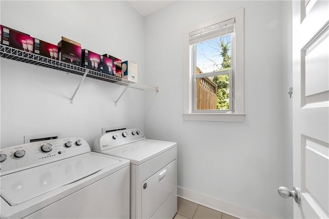 laundry room featuring washer and dryer, laundry area, light tile patterned flooring, and baseboards