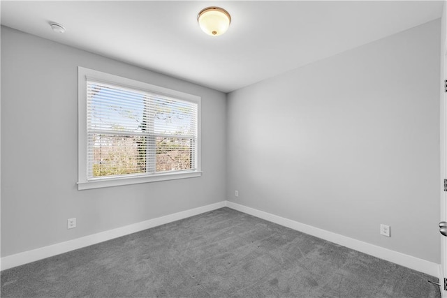 carpeted spare room featuring baseboards