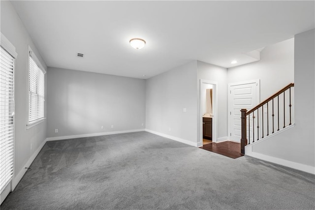 unfurnished room featuring baseboards, visible vents, stairway, dark carpet, and recessed lighting