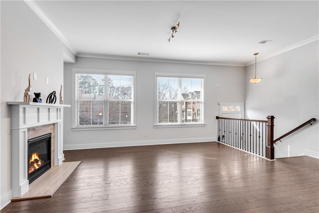 unfurnished living room with ornamental molding, visible vents, dark wood finished floors, and a premium fireplace