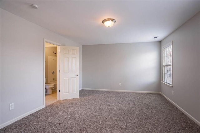 unfurnished room featuring visible vents, carpet floors, and baseboards