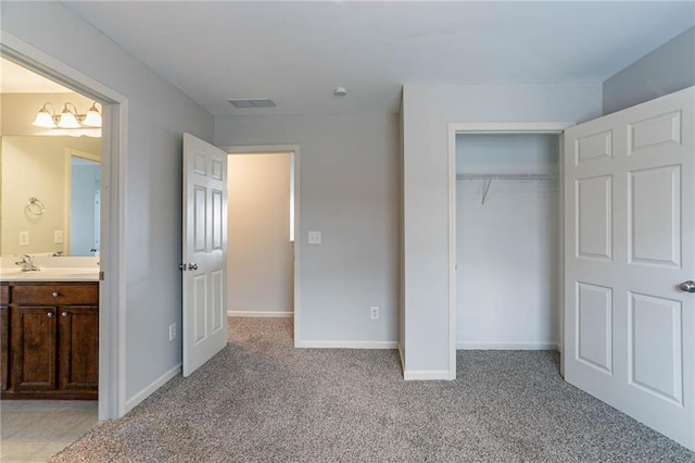 unfurnished bedroom with light colored carpet, visible vents, ensuite bathroom, and baseboards