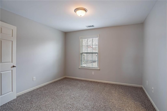 spare room featuring visible vents, baseboards, and carpet