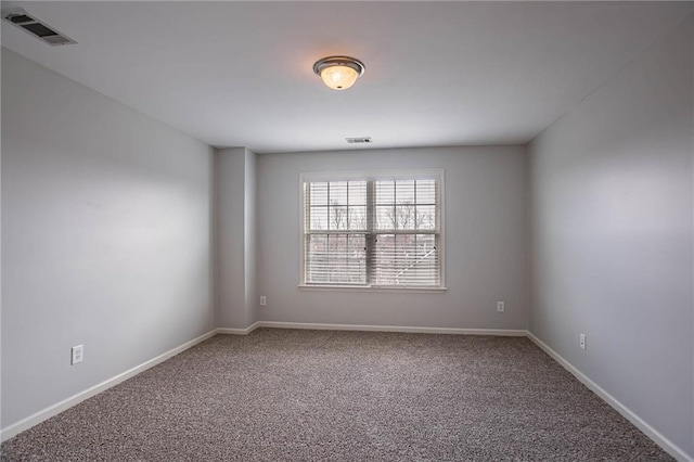 carpeted spare room with baseboards and visible vents