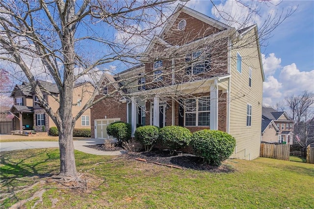 view of front of house featuring a garage, driveway, a front lawn, and fence