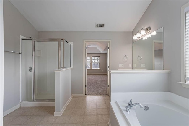 bathroom with visible vents, a shower stall, baseboards, lofted ceiling, and a garden tub