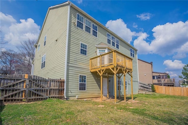 rear view of house with a lawn, fence, and a wooden deck