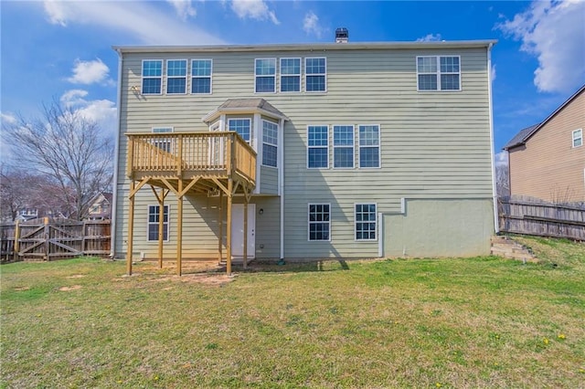 rear view of property with a deck, a lawn, and a fenced backyard