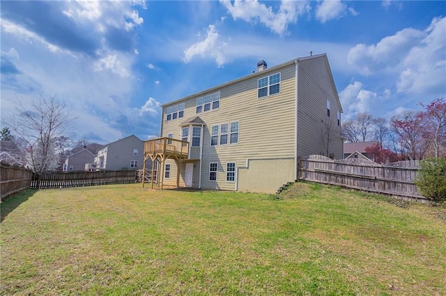 rear view of property featuring a deck, a lawn, and a fenced backyard