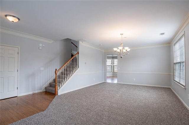 carpeted empty room featuring visible vents, stairway, crown molding, baseboards, and a chandelier