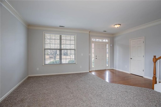 entryway featuring visible vents, baseboards, dark wood finished floors, ornamental molding, and dark colored carpet