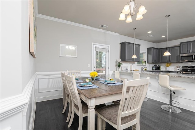3302 Bellingham Way, Lithia Springs, GA 30122 - dining area with dark wood-style floors, a chandelier, a wainscoted wall, crown molding, and a decorative wall