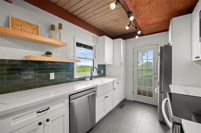 kitchen featuring tasteful backsplash, rail lighting, wooden ceiling, white cabinetry, and appliances with stainless steel finishes