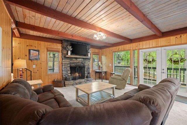 living area featuring beamed ceiling, a fireplace, carpet, and a wealth of natural light