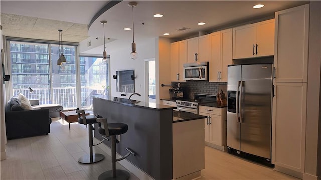 kitchen featuring dark countertops, floor to ceiling windows, a kitchen bar, decorative backsplash, and stainless steel appliances