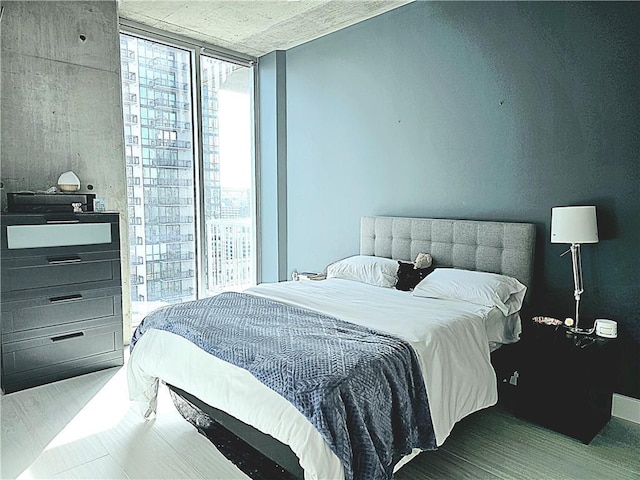 bedroom featuring expansive windows and wood finished floors