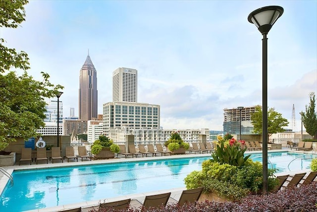 pool featuring a patio area, a city view, and fence