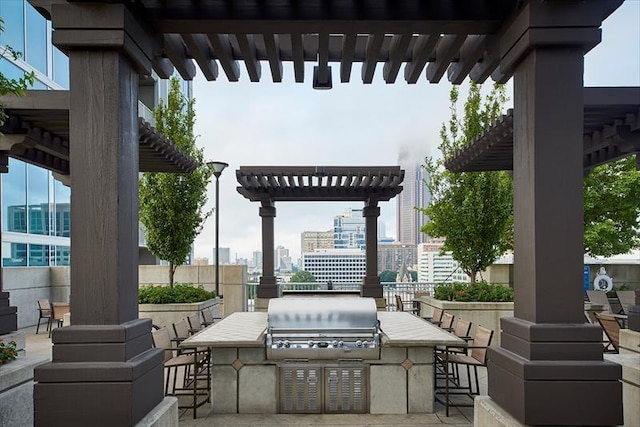 view of patio / terrace with grilling area, a city view, outdoor wet bar, an outdoor kitchen, and a pergola