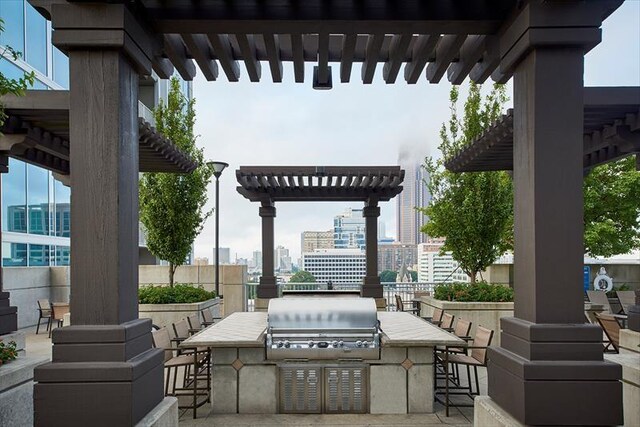 view of patio / terrace with a city view, area for grilling, a pergola, outdoor wet bar, and an outdoor kitchen