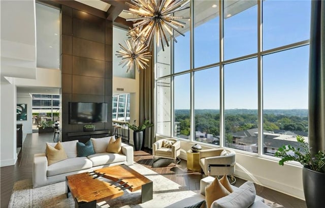 living room featuring baseboards, an inviting chandelier, and a towering ceiling