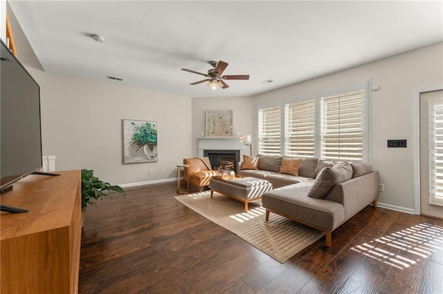 living room featuring ceiling fan and dark hardwood / wood-style floors