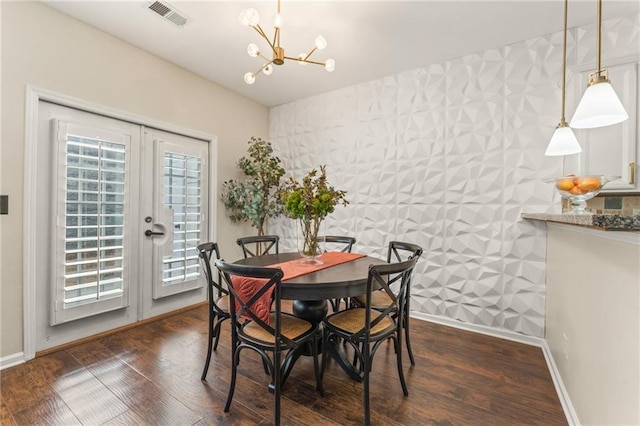 dining space featuring dark wood-type flooring, an inviting chandelier, and french doors