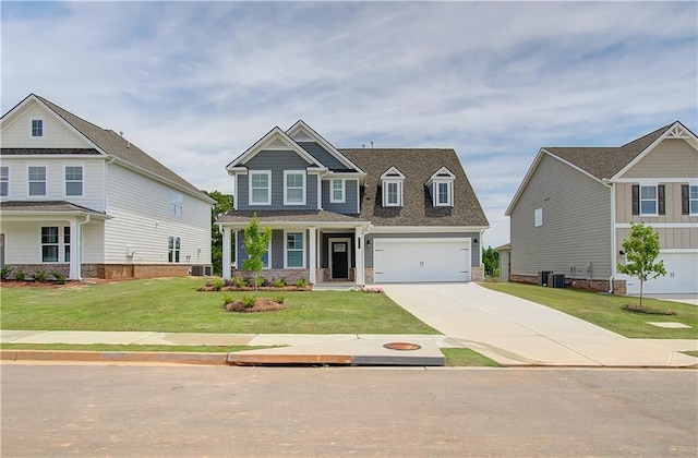 craftsman-style home with an attached garage, driveway, a front yard, and central air condition unit