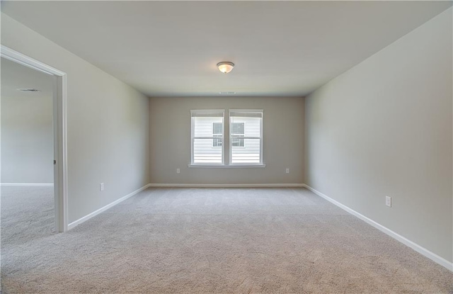 carpeted spare room with visible vents and baseboards