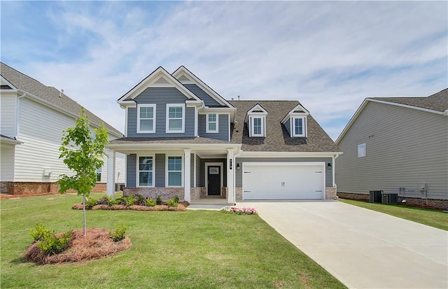 craftsman-style home featuring a front yard, concrete driveway, an attached garage, and central air condition unit