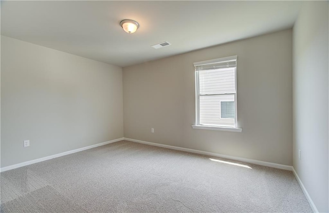 empty room featuring visible vents, baseboards, and carpet flooring