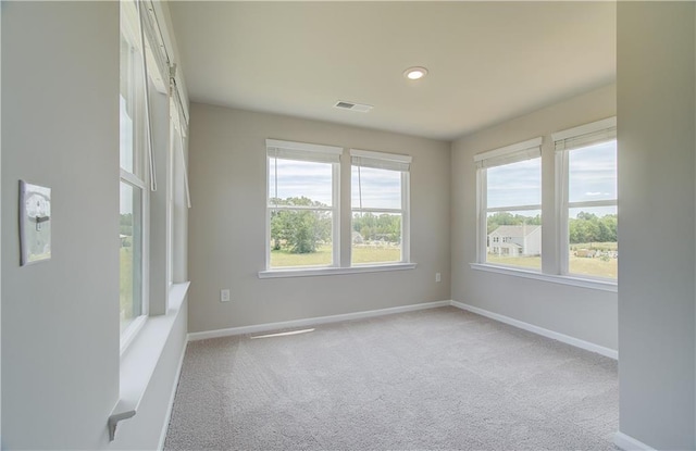 spare room with recessed lighting, carpet flooring, visible vents, and baseboards