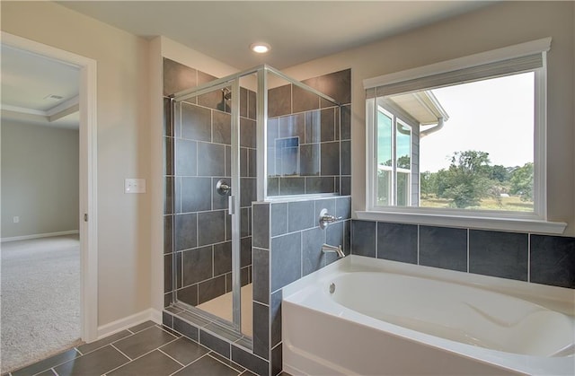 full bathroom featuring tile patterned flooring, a garden tub, a shower stall, and baseboards