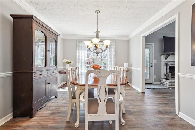 dining space with crown molding, a textured ceiling, and wood finished floors