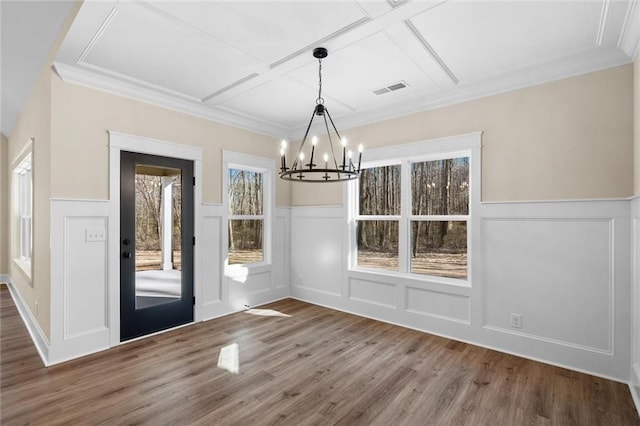 473 Nugget Rd, Carrollton, GA 30117 - unfurnished dining area with a notable chandelier, visible vents, a decorative wall, ornamental molding, and wood finished floors