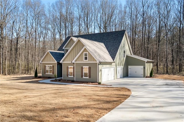 473 Nugget Rd, Carrollton, GA 30117 - view of front of house featuring concrete driveway, board and batten siding, a forest view, and roof with shingles