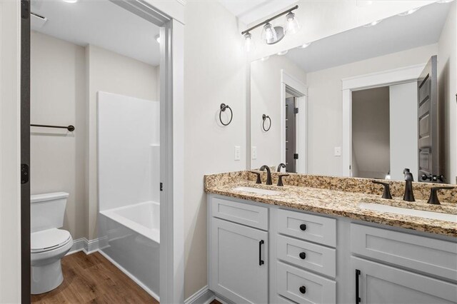 473 Nugget Rd, Carrollton, GA 30117 - full bath with toilet, double vanity, a sink, and wood finished floors