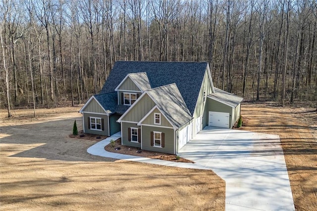 473 Nugget Rd, Carrollton, GA 30117 - view of front of home featuring board and batten siding, concrete driveway, roof with shingles, and a view of trees