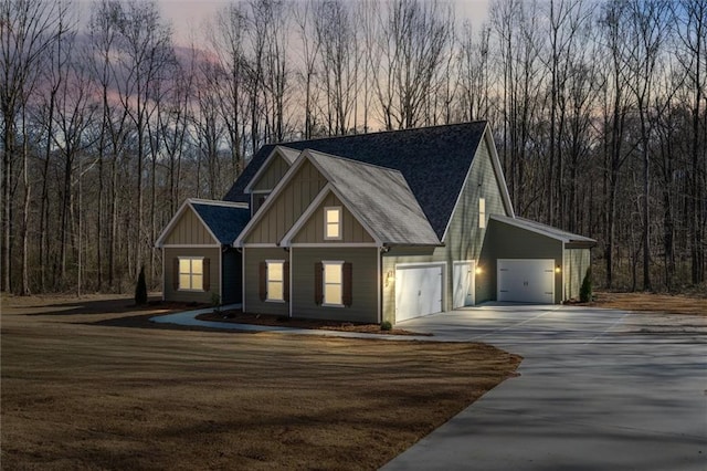 473 Nugget Rd, Carrollton, GA 30117 - view of front facade featuring a garage, a forest view, driveway, and board and batten siding