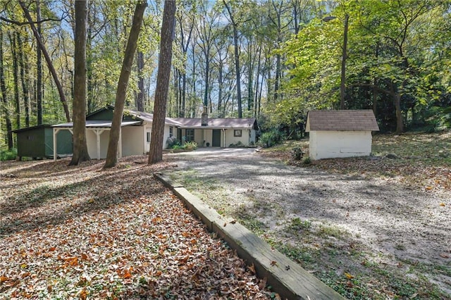 single story home featuring a shed