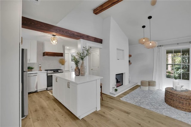 kitchen with appliances with stainless steel finishes, decorative light fixtures, white cabinetry, a center island, and custom range hood