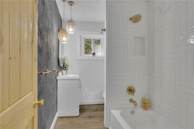 full bathroom featuring tiled shower / bath, wood-type flooring, sink, and toilet