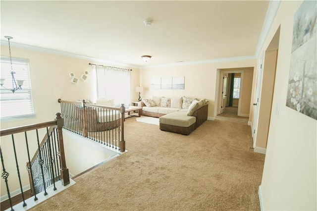 carpeted living room featuring a notable chandelier, crown molding, and baseboards